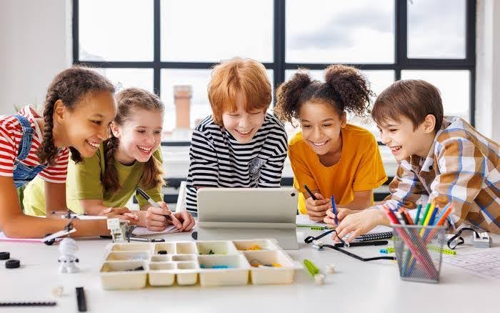 Group of schoolchildren using a tablet and STEM kits, demonstrating hands‑on study and skill development at GNWS Greater Noida.